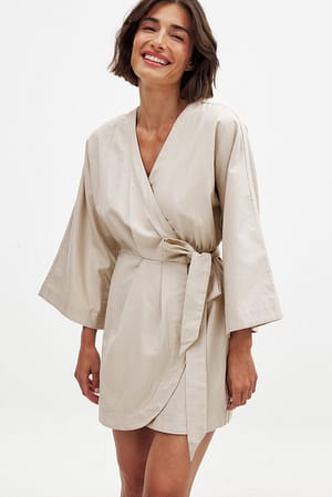 Beige Kaftan-miniklänning i linneblandning med omlottdetalj