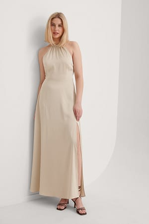 Beige Klänning Med En Öppen Rygg Och En Slits